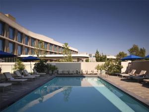 a swimming pool with lounge chairs and a hotel at Hilton Arcadia Los Angeles in Arcadia