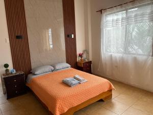 a bedroom with a bed with two towels on it at Stefany Hospedaje in Puerto Ayora