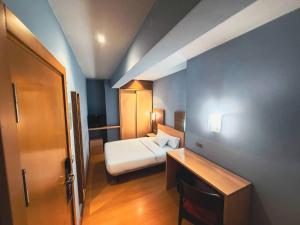 a small hotel room with a bed and a door at Hotel Faranda Alisas Santander, Ascend Hotel Collection in Santander +73 photos