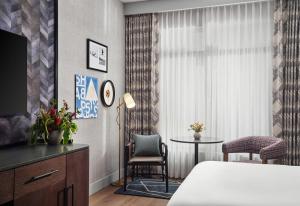 a bedroom with a bed and a table and a window at Canopy By Hilton Deer Valley in Park City