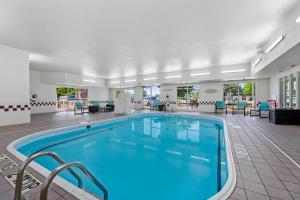 a pool in a hotel lobby with tables and chairs at MainStay Suites Appleton Airport - Fox River Mall Area in Appleton