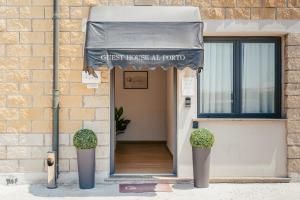 an entrance to a building with an awning and two plants at Guest House al porto in Civitavecchia
