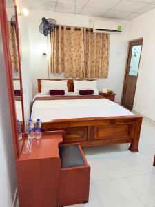 a bedroom with a large bed and a desk with a chair at Hotel Camorich in Tissamaharama +55 photos