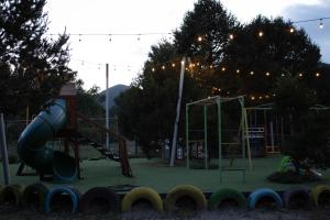 a park with a playground with a slide at Pinitos Old Ranch & Cabañas in El Cristal +6 photos