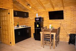 a kitchen and dining room with a table and a television at Pinitos Old Ranch & Cabañas in El Cristal