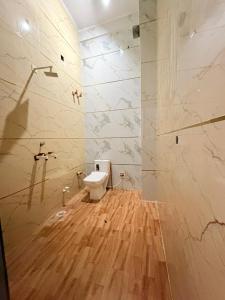 a bathroom with a toilet on a wooden floor at Nisha sadan in Vrindāvan
