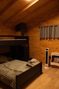 a bedroom with a bed and a fan and a window at Pinitos Old Ranch & Cabañas in El Cristal