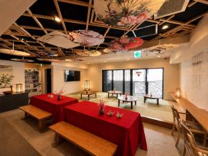 a room with two tables with red table cloth at HOTEL WINDS ASAKUSA Capsule Inn 浅草 in Tokyo