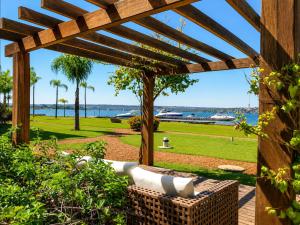 a wooden pergola with a bench in a park at Comfortable Serviced Apartment by the Lake in Brasília