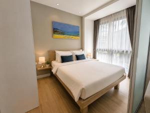 a bedroom with a large bed and a window at Pool View 1 BR Apt for 3 - Diamond Condo 5209 in Bang Tao Beach +10 photos