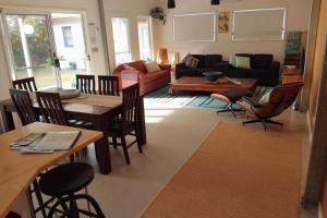a living room with a table and chairs at Sojourne - Walk to beach and Golf Club! in Shoalhaven Heads