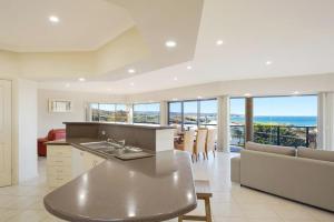 a kitchen and living room with a view of the ocean at Kyeema in Tathra