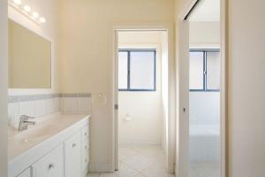 a white bathroom with a sink and a shower at Kyeema in Tathra +20 photos