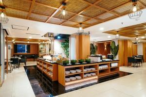 a restaurant with a counter with food on it at ASTON Pluit Hotel & Residence in Jakarta