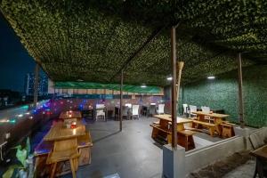 a restaurant with tables and chairs and a green wall at ASTON Pluit Hotel & Residence in Jakarta