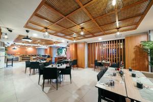 a restaurant with tables and chairs in a room at ASTON Pluit Hotel & Residence in Jakarta