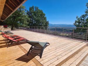 a deck with two chairs sitting on top of it at Le Vernay en Savoie - Petit Hôtel Nature in Saint-Maurice-de-Rotherens