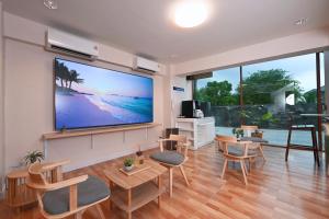 a living room with a large flat screen tv on the wall at Stay C Hotel in Ban Samet