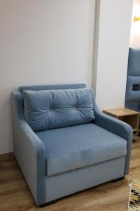 a blue couch sitting in a living room at Enma Rooms in Krujë