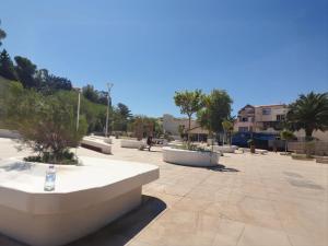 a park with concrete benches and trees and buildings at Apartment rental for vacations in Boumerdes