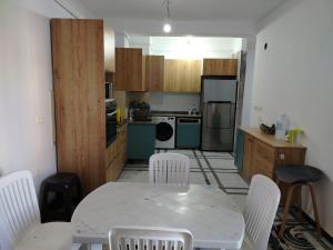 a kitchen with a table and white chairs in a room at Apartment rental for vacations in Boumerdes