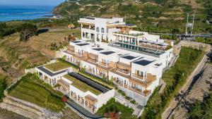 an aerial view of a large white building with plants at Sereno Lombok Resort in Selong Belanak