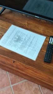 a piece of sheet music sitting on a table with a remote control at Dimora Fenni - Appartamento elegante nel cuore di Monte Isola con Wi-Fi e aria condizionata in Monte Isola