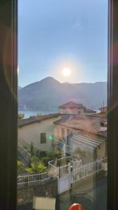 a view from a window of a city with the sun setting at Dimora Fenni - Appartamento elegante nel cuore di Monte Isola con Wi-Fi e aria condizionata in Monte Isola