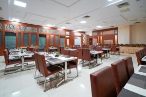 a restaurant with tables and chairs in a room at Open Hotel by Olive - Ambicas Grand in Visakhapatnam +10 photos