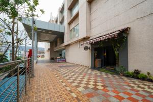 a building with a tiled sidewalk in front of it at Open Hotel by Olive - Ambicas Grand in Visakhapatnam