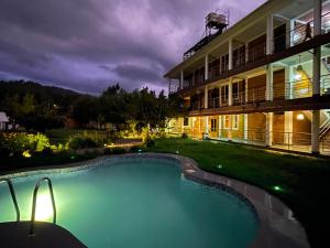 a swimming pool in front of a building at night at Runaway Hotel in Carhuaz