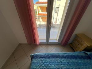 a bedroom with a bed and a large window at Asfodelo in Galtellì
