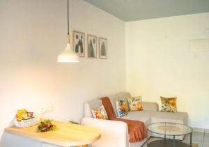 a living room with a couch and a table at Oshana Stays,Fully furnished Studio Apartment with Pool,Sauna,Siolim, Goa in Mapusa
