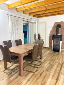 a wooden table and chairs in a living room with a fireplace at Villa Eden Prijecani in Banja Luka