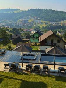 a group of chairs and umbrellas next to a pool at Chalet Panorama (Апартаменти) in Bukovel