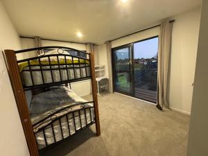 a bunk bed in a room with a balcony at Duo Duo in Auckland