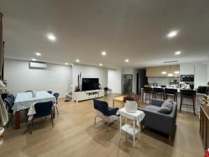 a living room with a couch and a table and a kitchen at Duo Duo in Auckland