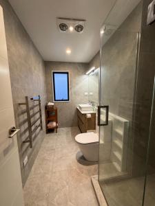 a bathroom with a toilet and a glass shower at Duo Duo in Auckland +28 photos