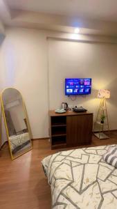 a bedroom with a bed and a tv on a wall at Skycabinomaxe in Greater Noida