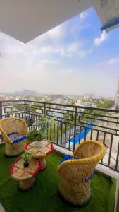 a balcony with three chairs and a table on top at Skycabinomaxe in Greater Noida