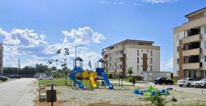 a playground with a slide in a parking lot at Merci Apartament 1,0 in Sibiu