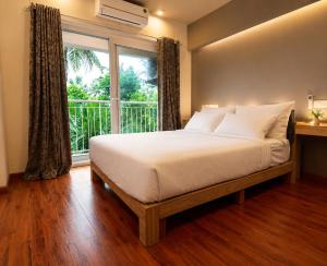 a bedroom with a bed and a large window at Transit Suites by GrandWest in Nedumbassery