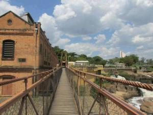 a bridge over a river next to a building at Pousada Sol do Salto Estância in Salto