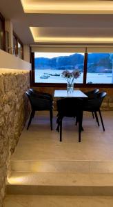 a dining room with a table and chairs and a large window at Villa Brodetto, Sveti Stefan in Pržno