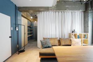 a living room with a couch in front of a window at Liminal in Atami