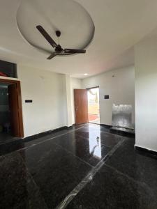 an empty living room with a ceiling fan at Nishhh stay in Surūrnagar