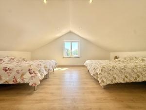 a attic bedroom with two beds and a window at Les Ecrins in Vigneulles-lès-Hattonchâtel