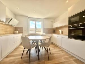 a kitchen with a table and chairs and a window at Les Ecrins in Vigneulles-lès-Hattonchâtel