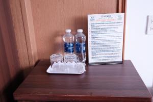 two bottles of water and two glasses on a table at Khách sạn Lumea in Cam Ranh