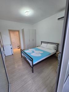 a bedroom with a bed with a blue blanket at VasilikiApartments in Vasiliki +2 photos